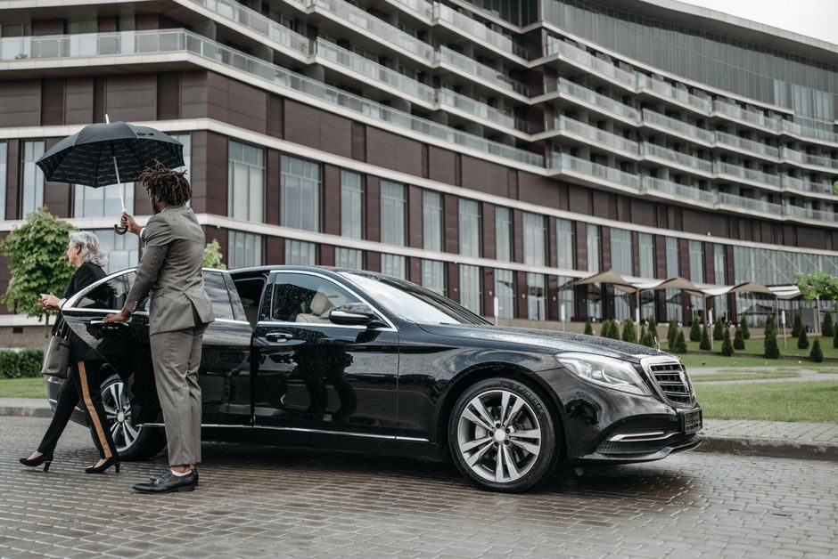 Chauffeur accompagnant une passagère jusqu'à la portière du véhicule