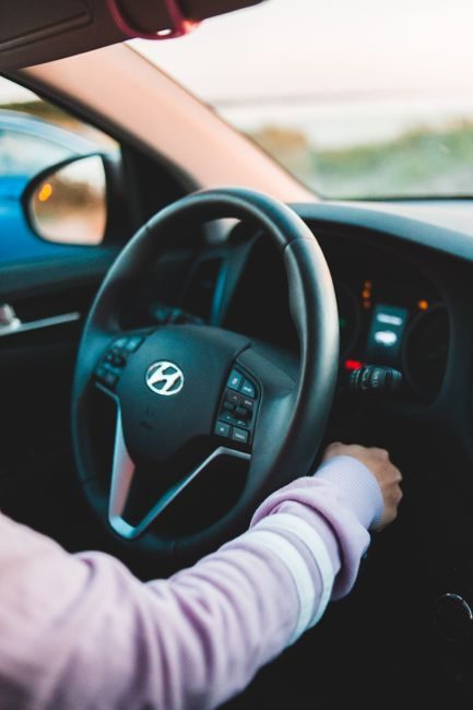 Mains au volant d'un taxi au départ d'une course, illustration du métier de chauffeur